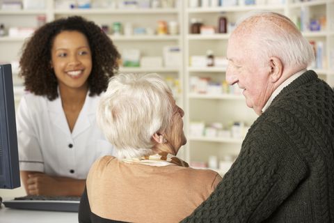 A couple speaks to a pharmacist at the counter Medication Therapy Managament
