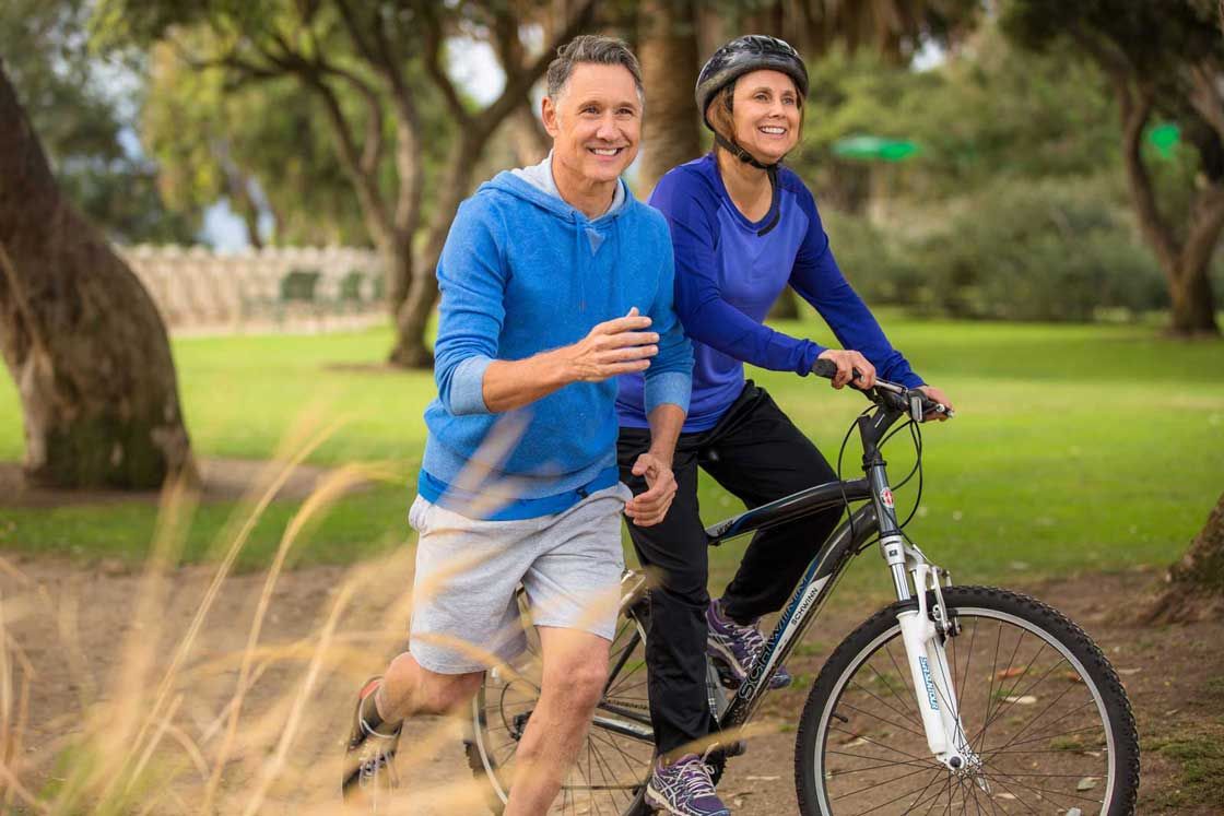 A man jogs next to a woman on a bike Hormone Balancing